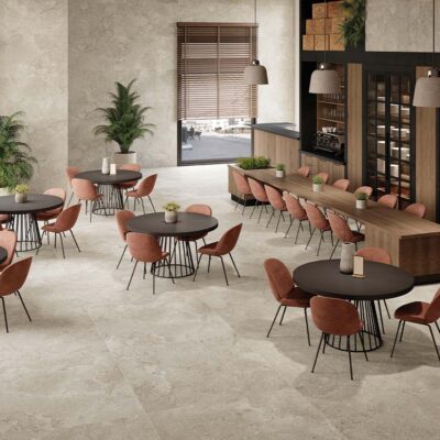 Restaurante contemporáneo con pavimento porcelánico efecto piedra caliza en gran formato, ideal para suelos de alto tránsito en espacios comerciales elegantes y funcionales.