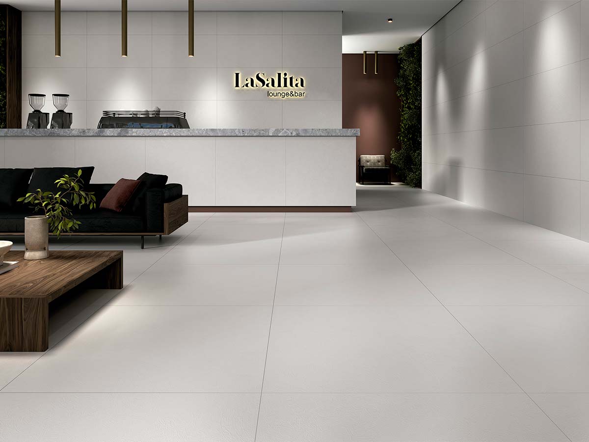 Salón de estilo industrial con suelo porcelánico Phase efecto cemento gris