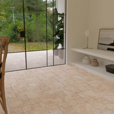 Salón con suelo rústico interior de baldosas de barro en tonos claros y grandes ventanales al jardín.