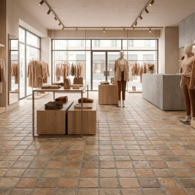 El suelo porcelánico rústico Benisa Teja cubre una moderna tienda de ropa.