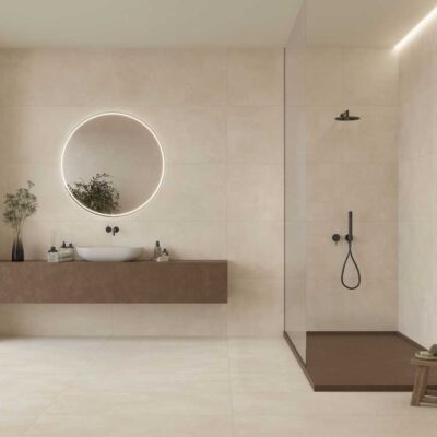 Baño moderno con suelo porcelanico efecto cemento Lardenne Crema y paredes a juego.