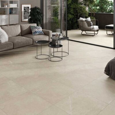 Sala de estar moderna con baldosas de color beige claro que se extienden a la terraza. El suelo tiene un acabado mate con textura sutil.