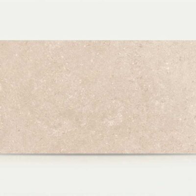 Azulejo porcelánico rectangular de color beige claro con textura de piedra natural.
