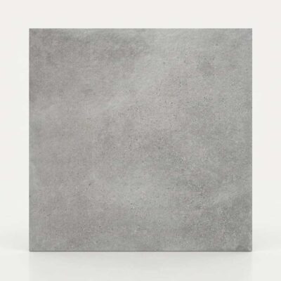 Azulejo porcelánico gris claro con textura de cemento sobre fondo blanco.