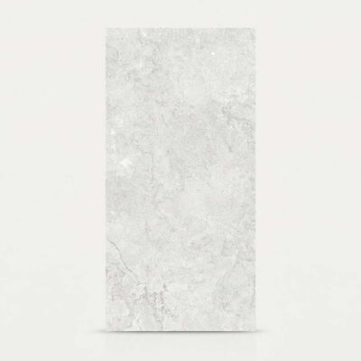 Azulejo porcelánico gris con textura de piedra sobre fondo neutro.