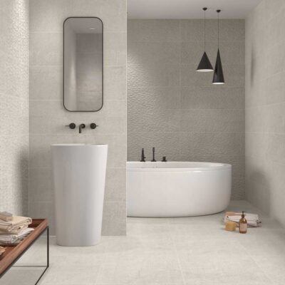 Baño moderno con azulejos efecto piedra Newbury Sand en paredes y suelo porcelánico.