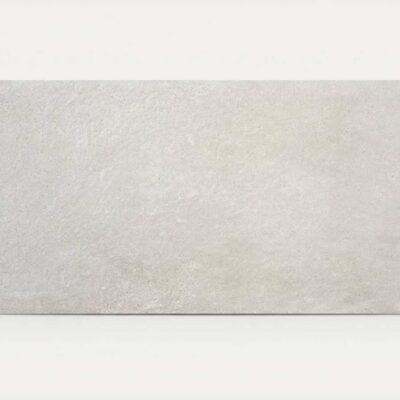 Una baldosa rectangular de porcelánico con efecto cemento gris claro.