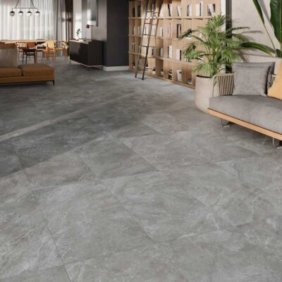 Amplio salón moderno con suelo de gres gris de acabado mate. El suelo presenta un diseño con vetas sutiles.