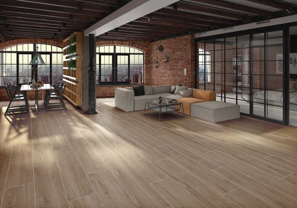 Amplio salón con suelo porcelánico imitación madera Ninsba Camel en tono claro.