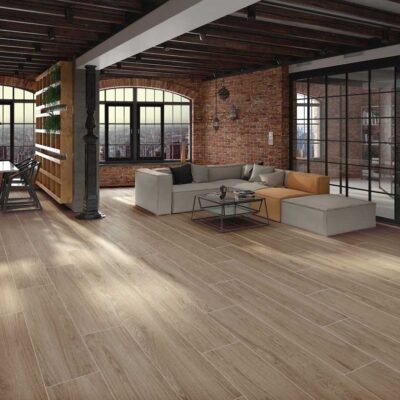 Amplio salón con suelo porcelánico imitación madera Ninsba Camel en tono claro.