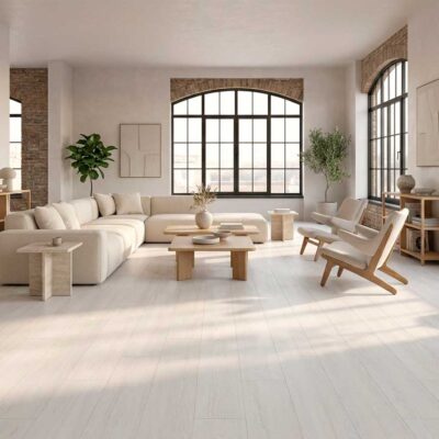 Amplio salón con suelo porcelánico imitación madera Ninsba White. Muebles claros y grandes ventanales.