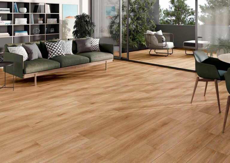 El suelo porcelánico imitación madera Nordby Honey luce en un salón con balcón.