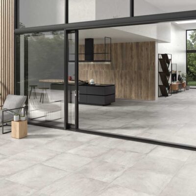 Suelo porcelánico Stoneage Concrete antideslizante en un moderno salón y terraza.