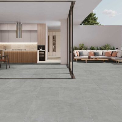 Suelo porcelánico efecto cemento gris oscuro en una cocina y terraza modernas.