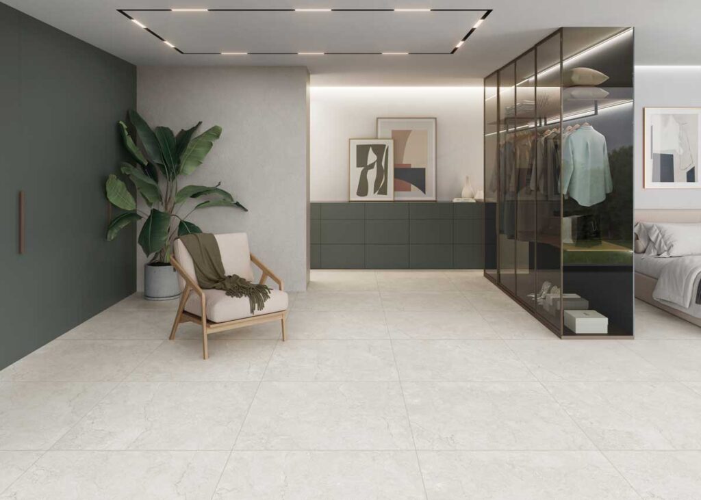 Suelo porcelánico Gobi Ivory 1 en un dormitorio moderno con armario de cristal y planta.