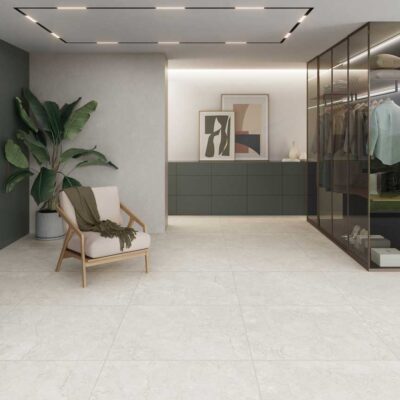 Suelo porcelánico Gobi Ivory 1 en un dormitorio moderno con armario de cristal y planta.