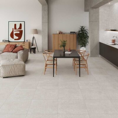 Suelo porcelánico imitación cemento Leiria Greige en un salón-cocina moderno.