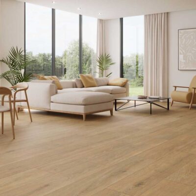 Salón moderno con suelo porcelánico imitación madera Haspe Roble. Sofá claro y ventanales.