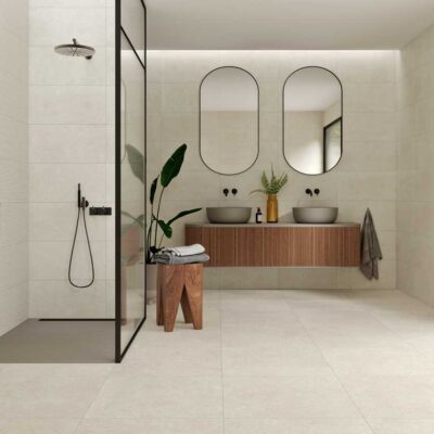 Baño moderno con suelo porcelánico efecto cemento Leiria natural y ducha de cristal.