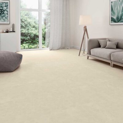 Sala de estar con suelo porcelánico efecto cemento beige. Ventanal y sofá gris.