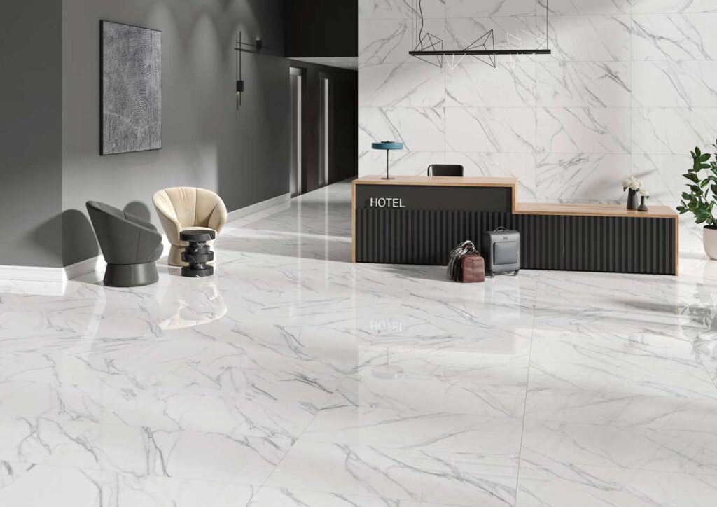 Lobby de hotel moderno con elegantes suelos porcelánicos blancos de efecto mármol y acabado pulido. Las baldosas grandes reflejan la luz.