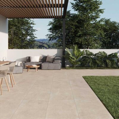 Patio exterior moderno con suelo porcelánico beige claro de acabado mate. Un espacio elegante con mobiliario y vegetación.