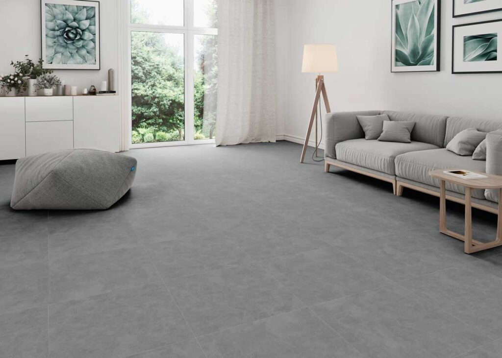 Suelo porcelánico imitación cemento Lardenne Marengo en salón con sofá y puf.