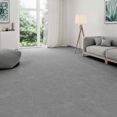 Suelo porcelánico imitación cemento Lardenne Marengo en salón con sofá y puf.