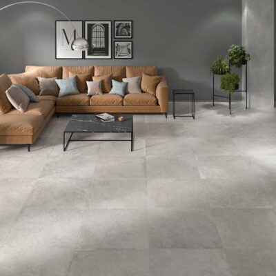 Sala de estar moderna con suelos porcelánicos de color gris claro y acabado mate. El diseño sutil se integra con la decoración contemporánea.