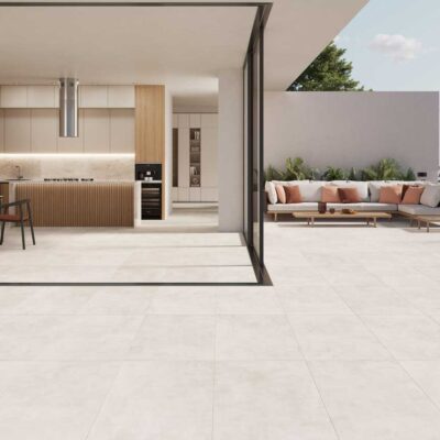 Suelo porcelánico Columbia Pearl claro conecta cocina y terraza exterior.
