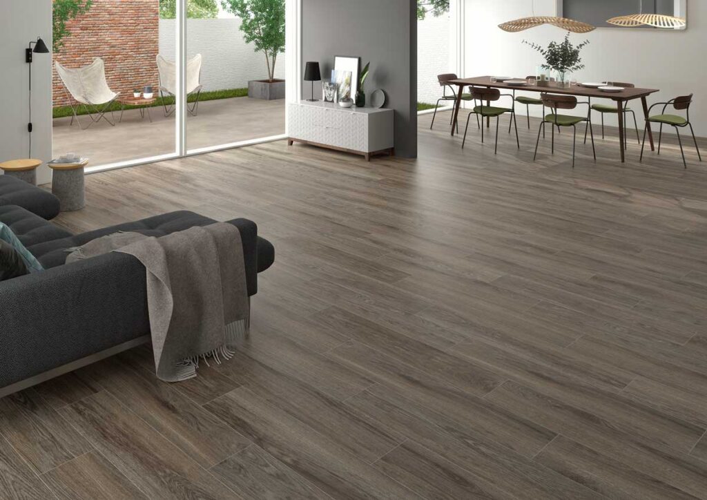 Un moderno salón y comedor luce suelo porcelánico imitación madera Ninsba Brown.