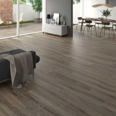 Un moderno salón y comedor luce suelo porcelánico imitación madera Ninsba Brown.