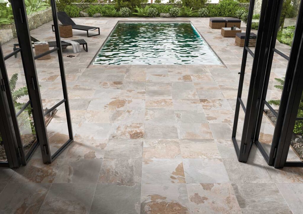 Patio exterior con piscina y suelo porcelánico imitación piedra Castleford gris.