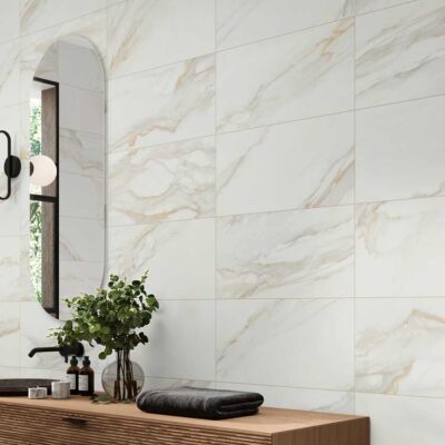 Pared de baño con azulejo porcelánico imitación mármol Golden Hill blanco y vetas doradas.