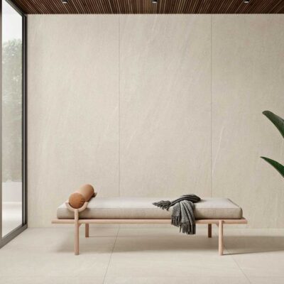 Salón moderno con suelo y pared de porcelánico Halton Cream imitación piedra. Vent