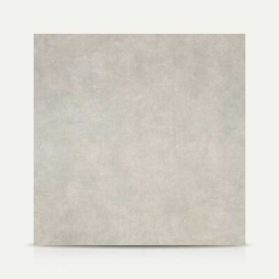 Se muestra una baldosa porcelánica Vanguard Perla gris claro con textura de cemento.