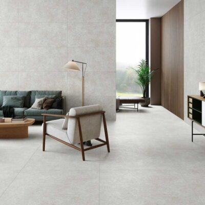 Salón moderno con suelo porcelánico efecto piedra Lomma Grey y pared a juego.