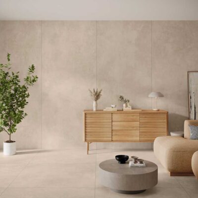 Sala de estar con suelo porcelanico y paredes en tono crema efecto cemento.