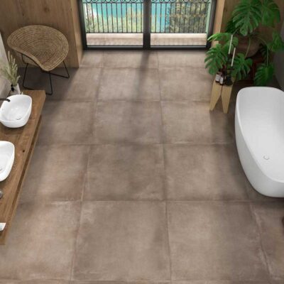 Baño moderno con suelo porcelánico Lecco Mocca imitación cemento. Incluye bañera y lavabos.