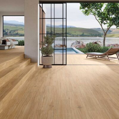 Suelo porcelanico imitando madera en un dormitorio y terraza con piscina y vistas al lago.