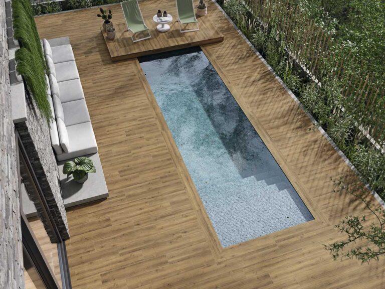 Suelo porcelánico imitación madera Concorde Natural rodea una piscina moderna con zona de relax.