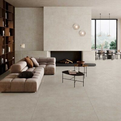 Amplio salon moderno con suelo porcelanico Lomma Bone. Se aprecian un sofa, chimenea y comedor.