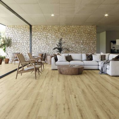 Suelo porcelánico imitación madera Concorde Miel en un salón moderno con sofá blanco.