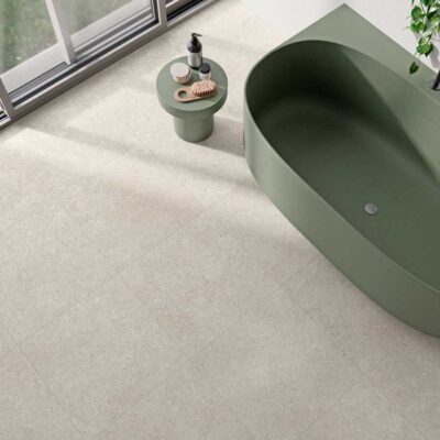Suelo porcelánico Lomma Bone antideslizante en un baño con bañ