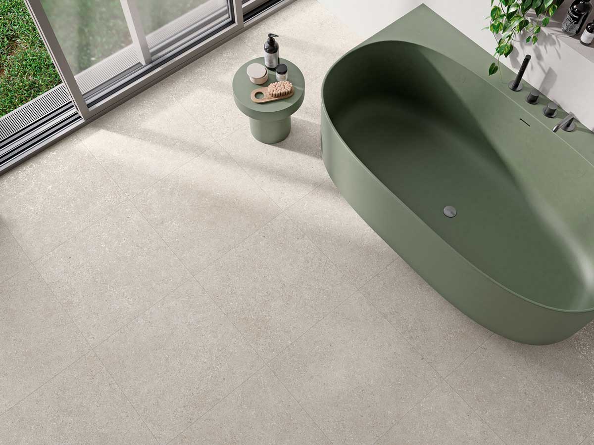 Suelo porcelánico Lomma Bone antideslizante en un baño con bañ