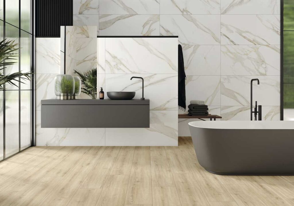 Baño moderno con suelo de porcelánico imitación madera Concorde Haya y paredes de mármol blanco.