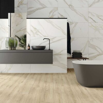 Baño moderno con suelo de porcelánico imitación madera Concorde Haya y paredes de mármol blanco.