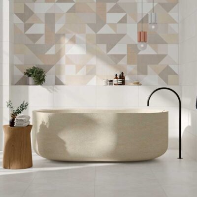 Suelo porcelánico blanco en un baño moderno con bañera exenta y pared geométrica.