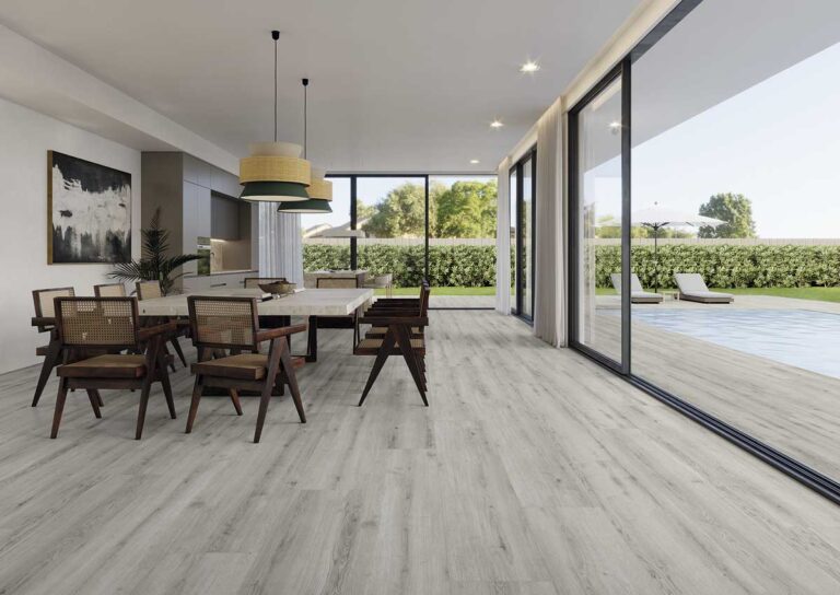 Moderno comedor con suelo porcelánico efecto madera Concorde Grey. Grandes ventanales dan a una piscina.