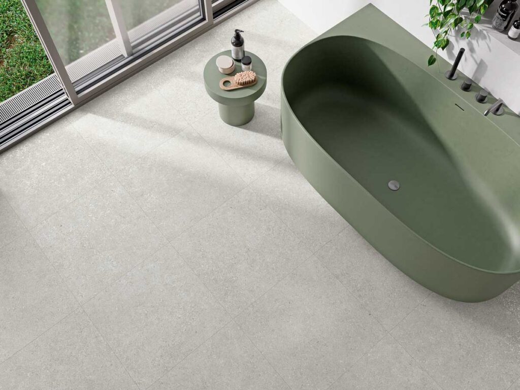 Baño moderno con suelo porcelánico gris claro antideslizante y bañera
